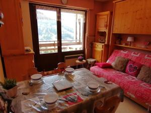 ein Wohnzimmer mit einem Tisch und einem Sofa in der Unterkunft Appartement Le Grand-Bornand, 1 pièce, 4 personnes - FR-1-241-221 in Le Grand-Bornand