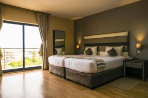 a bedroom with a large bed and a large window at WL Hotel Maputo City Center Mozambique Collection in Maputo