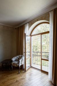 a living room with a large window and a chair at GANZ HOTEL in Ivano-Frankivsʼk
