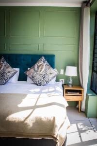 ein Schlafzimmer mit einem Bett und einem Tisch mit einer Lampe in der Unterkunft Le Rêve Boutique Hôtel in Tulbagh