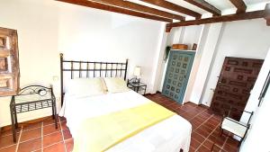 um quarto com uma cama branca e uma porta azul em Casa Rural Casasola em Chinchón