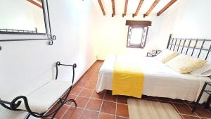 um quarto com uma cama e uma cadeira num quarto em Casa Rural Casasola em Chinchón