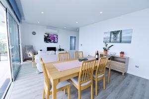 a dining room and living room with a table and chairs at Casa Mar Azul in Arco da Calheta