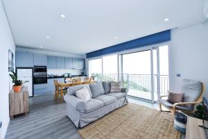 a living room with a couch and a kitchen at Casa Mar Azul in Arco da Calheta
