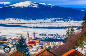 a city with a snowy mountain in the background at Kupres, centar, 1bdr apt in Kupres