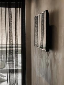 una ventana con cortina y espejo en CASAGOLD Glyfada Luxury Apartment Near The Sea, en Atenas