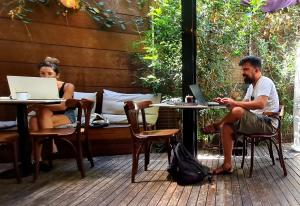 een man en een vrouw aan een tafel met laptops bij Assemblage Boutique in Tel Aviv