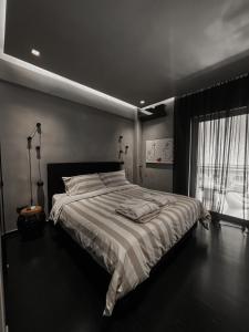 Un dormitorio con una cama grande y una ventana en CASAGOLD Glyfada Luxury Apartment Near The Sea, en Atenas