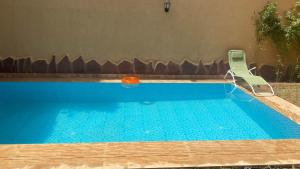 a swimming pool with a chair and a orange ball at Villa Targa in Marrakesh