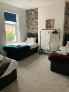 a room with two beds and a window at Dukes Place sleeps 10 comfortably in Wolverhampton