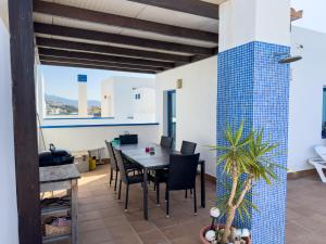 a dining room with a table and a blue tile wall at Penthouse by the beach in Torrox Costa