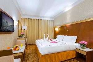 Habitación de hotel con cama grande y TV en Dhiafat Al Raja Hotel, en La Meca