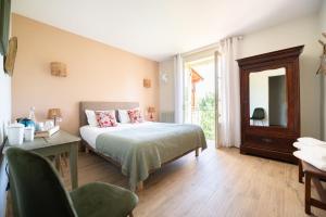 - une chambre avec un lit, un bureau et un miroir dans l'établissement LE CLOS VERSAILLES BEYNAC, à Beynac-et-Cazenac