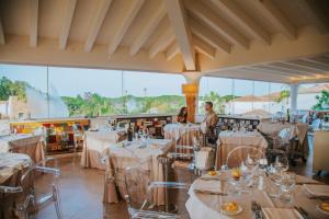 two people sitting at tables in a restaurant at Corte Bianca - Adults Only & SPA - Bovis Hotels in Cardedu