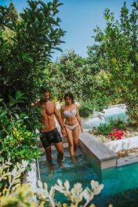 um homem e uma mulher de pé na água junto a uma piscina em Corte Bianca - Adults Only & SPA - Bovis Hotels em Cardedu