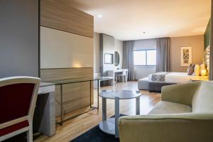 マプトにあるWL Hotel Maputo City Center Mozambique Collectionのベッドとリビングルームが備わるホテルルームです。