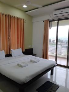 a bedroom with a large white bed with a window at Hotel Shiva's Inn in Trimbak