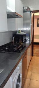 a kitchen with a stove and a washing machine at Habitaciones individuales en apartamento turístico in Madrid