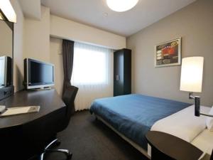 a hotel room with a bed and a desk at Hotel Route-Inn Shibukawa in Shibukawa