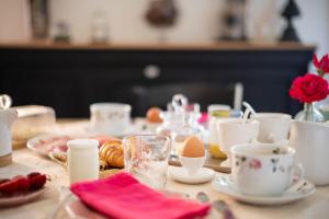 una mesa con huevos, tazas y galletas. en LE CLOS VERSAILLES BEYNAC, en Beynac-et-Cazenac