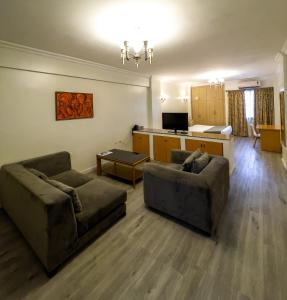 een woonkamer met 2 banken en een keuken bij Maroko Bayshore Suites in Lagos