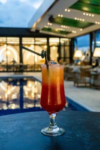 拉各斯的住宿－摩洛哥海柏套房酒店，坐在游泳池旁的桌子上喝一杯