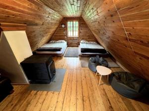 Habitación con 3 camas en una cabaña de madera en Silamalas, en Tukums
