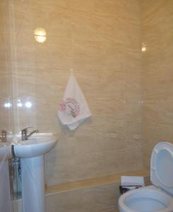 a bathroom with a sink and a toilet and a towel at Жетысу-3 дом 50 in Almaty +12 photos