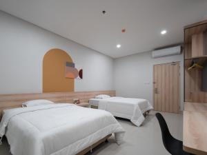 a hotel room with two beds and a tv at Cove Bona Sort Pasar Baru in Jakarta
