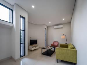 a living room with a green couch and a tv at Cove Bona Sort Pasar Baru in Jakarta