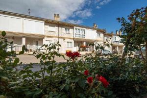 un grand bâtiment avec des roses rouges devant lui dans l'établissement Casa Rural Hacienda Montorio, à Montorio