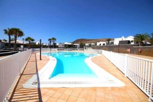 a large swimming pool with a white fence around it at Cotton House in Playa Blanca