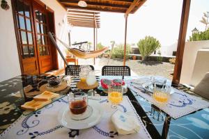 una mesa con comida y bebidas encima en Cotton House, en Playa Blanca