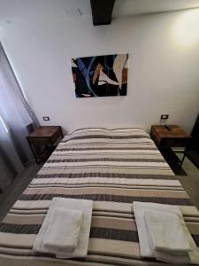 una camera da letto con un grande letto con due tavoli di Alloggiamo a Modena