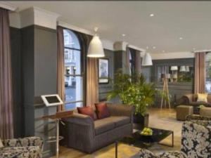 ein Wohnzimmer mit einem Sofa und einem Tisch in der Unterkunft Well Presented Spacious 1 Bed Flat In Kensington in London