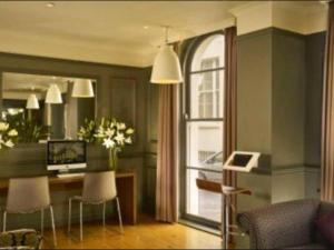ein Wohnzimmer mit einem Schreibtisch und einem Fenster in der Unterkunft Well Presented Spacious 1 Bed Flat In Kensington in London