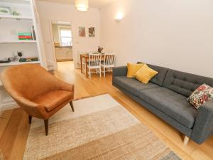 a living room with a couch and a chair at Potters Cottage in Sheffield