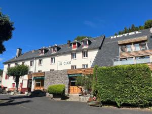 a large white building with a gray roof at Hotel Restaurant Le Clos in Besse-et-Saint-Anastaise