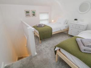 Habitación pequeña con 2 camas y ventana en Potters Cottage en Sheffield