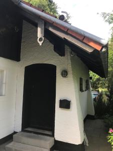a house with a black door and a roof at HARZchen in Sankt Andreasberg