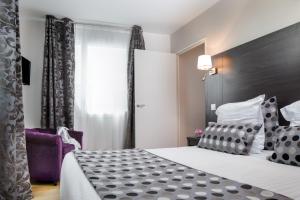 Habitación de hotel con cama y silla morada en Seven Urban Suites Nantes Centre, en Nantes