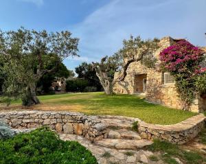 une maison en pierre avec un mur en pierre et des arbres dans l'établissement Tenuta Le Farcole by LoveSud, à Leuca