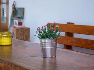 een metalen emmer met bloemen op een houten tafel bij Holderstanzenhof in Bad Peterstal-Griesbach