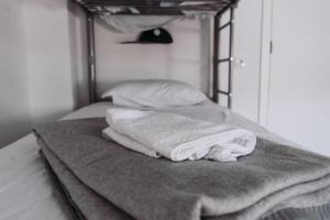 una pila de toallas sentadas encima de una cama en Hostel Middle Point en Sardoal