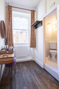 a bathroom with a toilet and a window at Palmers Lodge Swiss Cottage in London +37 photos