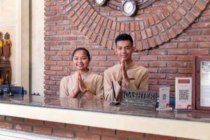 a man and a woman sitting at a counter with their hands in front at Anik Boutique Hotel in Phnom Penh