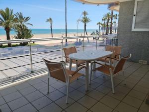 d'une table et de chaises sur un balcon donnant sur la plage. dans l'établissement Apartamentos-Atico Reformados Pompeya I y II, à Peñíscola