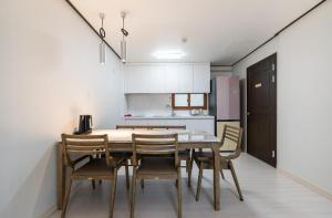 a kitchen with a dining room table and chairs at Hotel Lien in Busan