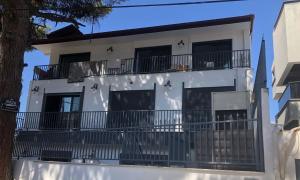 Casa blanca con balcones y un árbol en Lulubay Rooms & Suites en Kusadasi