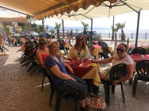 een groep vrouwen aan een tafel bij het strand bij Stunning Studio holiday apartment for 23 on resort, close to beach with 2 pools in Pizzo